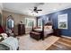 Elegant bedroom with a four-poster bed, wood floors and a stylish decorative mirror at 27016 N 20Th Ln, Phoenix, AZ 85085