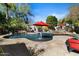 Backyard pool with mature landscaping, a built-in spa, rock waterfalls, poolside seating, and shade trees at 27016 N 20Th Ln, Phoenix, AZ 85085
