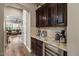 Stylish wet bar area featuring dark cabinets, granite countertop, wine cooler and tile backsplash at 27016 N 20Th Ln, Phoenix, AZ 85085