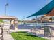 View of the community pool with slide, chairs, tables, and shade structures at 281 S San Gregorio Ln, Casa Grande, AZ 85194