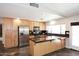 Bright kitchen with stainless steel appliances, wooden cabinets and a center island with bar seating at 2901 W Straford Dr, Chandler, AZ 85224