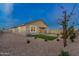 A well-maintained backyard features desert landscaping, a covered patio, and a patch of green grass for relaxing at 35961 W San Ildefanso Ave, Maricopa, AZ 85138
