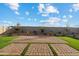 Wide backyard features an intricate brick paver patio with artificial grass accents at 35961 W San Ildefanso Ave, Maricopa, AZ 85138