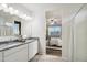 Elegant bathroom with double vanity sinks, granite countertops, and a view into the bedroom at 35961 W San Ildefanso Ave, Maricopa, AZ 85138