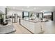Modern kitchen with stainless steel appliances, white cabinetry, and an island flowing into dining and living spaces at 35961 W San Ildefanso Ave, Maricopa, AZ 85138