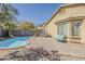 Backyard with a pool, a gravel landscape, a bench, and a block wall at 36307 W El Greco St, Maricopa, AZ 85138