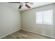 Bright bedroom showcasing wood-look flooring, a ceiling fan, and a window with blinds at 36307 W El Greco St, Maricopa, AZ 85138