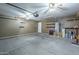 Spacious garage featuring concrete floors, shelving, and an automatic door opener at 36307 W El Greco St, Maricopa, AZ 85138