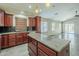 Stylish kitchen with a central island, wood cabinets, granite counters and stainless appliances at 36307 W El Greco St, Maricopa, AZ 85138