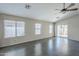 Open-concept living space with tile flooring, large windows and a sliding glass door at 36307 W El Greco St, Maricopa, AZ 85138