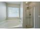 Bright bathroom with large soaking tub, a separate shower, and a large window at 36307 W El Greco St, Maricopa, AZ 85138