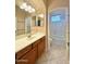 Bright bathroom features vanity with cabinets, decorative lights, and large mirror at 3807 E Latham Ct, Gilbert, AZ 85297