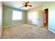 Spacious carpeted bedroom with two-tone walls, ceiling fan, and sunny window at 3807 E Latham Ct, Gilbert, AZ 85297