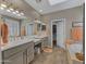 Bright bathroom featuring double sinks, a large mirror, and a soaking tub next to the walk-in closet at 41310 N Clear Crossing Ct, Anthem, AZ 85086