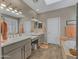 Bright bathroom featuring double sinks, a large mirror, and a soaking tub next to the walk-in closet at 41310 N Clear Crossing Ct, Anthem, AZ 85086