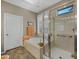 This light-filled bathroom is equipped with a glass-enclosed shower and soaking tub under shuttered windows at 41310 N Clear Crossing Ct, Anthem, AZ 85086