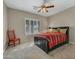 Comfortable bedroom with a ceiling fan, plantation shutters, and a large window overlooking the yard at 41310 N Clear Crossing Ct, Anthem, AZ 85086