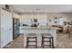 Modern kitchen with white cabinets, stainless steel appliances, and a granite-topped island with seating at 41310 N Clear Crossing Ct, Anthem, AZ 85086