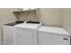 Appliance-filled laundry room featuring a washer and dryer set next to a large freezer and storage shelves at 41310 N Clear Crossing Ct, Anthem, AZ 85086