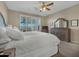 Comfortable main bedroom featuring a wooden bed frame, dresser, and views through plantation shutters at 41310 N Clear Crossing Ct, Anthem, AZ 85086