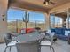 Covered patio featuring outdoor furniture and a view of the surrounding desert landscape with a large cactus at 41310 N Clear Crossing Ct, Anthem, AZ 85086