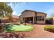 Beautiful backyard oasis featuring a putting green, mature trees, and a desert landscape at 42207 N 45Th Dr, Phoenix, AZ 85086