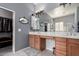 Bathroom with dual sinks, updated light fixtures, and a walk-in closet visible through an open door at 42207 N 45Th Dr, Phoenix, AZ 85086