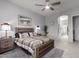 Spacious main bedroom features a king bed, ceiling fan, and an adjacent bathroom, perfect for rest and relaxation at 42207 N 45Th Dr, Phoenix, AZ 85086