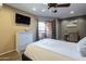 Comfortable bedroom featuring a balcony, work space, and tv, complete with a soft carpet and modern design at 4303 E Cactus Rd # 308B, Phoenix, AZ 85032