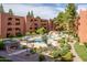 Stunning outdoor community pool area with water feature, mature trees, and seating at 4303 E Cactus Rd # 308B, Phoenix, AZ 85032
