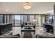 Elegant living room featuring floor-to-ceiling windows, modern furnishings, and a sleek bar area and game area at 4808 N 24Th St # 1305, Phoenix, AZ 85016