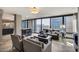 Well-appointed living room with floor-to-ceiling windows, modern furnishings, and a sleek bar area at 4808 N 24Th St # 1305, Phoenix, AZ 85016