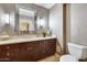 Elegant powder room featuring dark wood cabinets and a decorative mirror at 4808 N 24Th St # 1305, Phoenix, AZ 85016