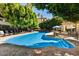 Large community pool with plenty of lounge chairs and tables with umbrellas under a blue sky at 5104 N 32Nd St # 431, Phoenix, AZ 85018