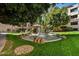 Lush garden with a water fountain surrounded by manicured green grass and rocks at 5104 N 32Nd St # 431, Phoenix, AZ 85018