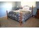 Cozy bedroom featuring neutral carpet, blue accent wall, and wrought iron bed frame at 5910 N 86Th St, Scottsdale, AZ 85250