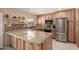 Bright kitchen featuring a large island, stainless steel appliances and natural wood cabinets at 5910 N 86Th St, Scottsdale, AZ 85250