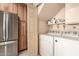 Convenient laundry area with modern stainless steel refrigerator, washer and dryer, and extra storage space at 5910 N 86Th St, Scottsdale, AZ 85250