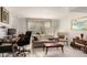Bright and airy living room featuring a comfortable sofa, large window, and a cozy seating area with a desk at 5910 N 86Th St, Scottsdale, AZ 85250