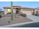 Well-maintained home featuring desert landscaping, a two-car garage, and decorative accents at 6513 S Fairway Dr, Gold Canyon, AZ 85118