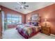 Bedroom with a ceiling fan, large window view, and bedside tables with lamps at 6513 S Fairway Dr, Gold Canyon, AZ 85118