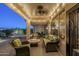 Inviting covered patio with comfortable seating, fire pit, and ambient string lights at 6513 S Fairway Dr, Gold Canyon, AZ 85118