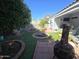 Spacious backyard with artificial grass, brick accents, and mature trees providing shade and privacy at 654 S 83Rd Way, Mesa, AZ 85208