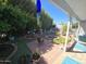 Charming backyard featuring lush landscaping, mature trees, and a cozy patio area with potted plants at 654 S 83Rd Way, Mesa, AZ 85208