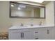 Bathroom with white cabinets, dual sinks, and a large decorative mirror at 654 S 83Rd Way, Mesa, AZ 85208