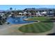 Aerial view of a scenic golf course with a pond, fountains and mountain views, ideal for golf enthusiasts at 654 S 83Rd Way, Mesa, AZ 85208