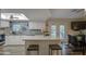 Well-lit kitchen with a center island, stainless steel sink, and adjacent dining area at 654 S 83Rd Way, Mesa, AZ 85208