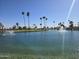 Scenic view of a pond with water features, lush landscaping, and palm trees, creating a serene environment at 654 S 83Rd Way, Mesa, AZ 85208