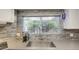 Close up of kitchen sink with stone tile backsplash and window overlooking lush greenery at 654 S 83Rd Way, Mesa, AZ 85208