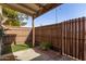 Charming back patio with a wooden fence, artificial turf, and decorative plants, ideal for outdoor relaxation at 6604 W Kingston Ln, Glendale, AZ 85306